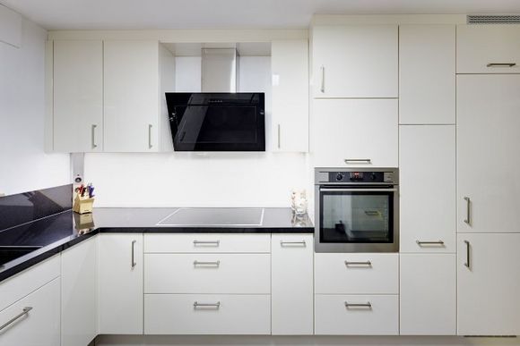 Moderne Küche mit weißen Schränken und schwarzen Arbeitsplatten